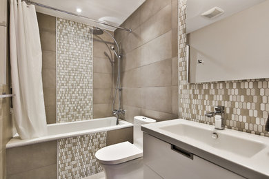 Example of a mid-sized trendy stone slab and gray tile porcelain tile drop-in bathtub design in Montreal with a console sink, a one-piece toilet and gray walls
