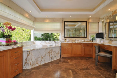 Medium sized classic ensuite bathroom in Los Angeles with a submerged sink, recessed-panel cabinets, medium wood cabinets, granite worktops, a corner bath and beige walls.