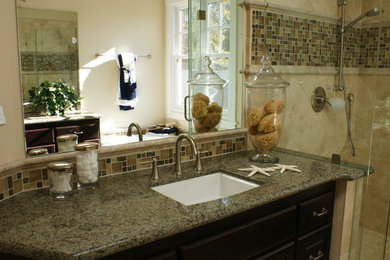 Inspiration for a mid-sized timeless master beige tile and stone slab marble floor bathroom remodel in San Francisco with an undermount sink, raised-panel cabinets, dark wood cabinets, granite countertops and beige walls