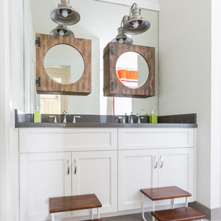 Photo of a beach style kids bathroom in Houston with recessed-panel cabinets, white walls, porcelain floors, an integrated sink and zinc benchtops.