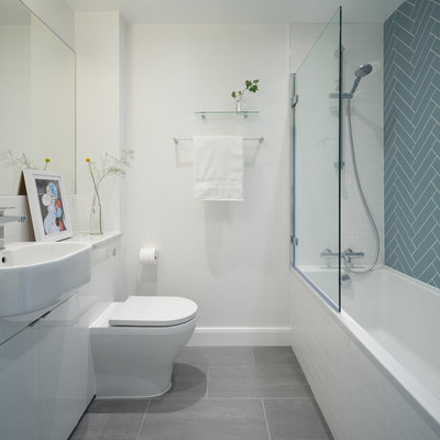 Bathroom - scandinavian 3/4 blue tile gray floor bathroom idea in London with flat-panel cabinets, white cabinets, a one-piece toilet, white walls, a drop-in sink, marble countertops and gray countertops