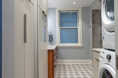 Small transitional porcelain tile and multicolored floor laundry room photo in Other with flat-panel cabinets, medium tone wood cabinets and blue walls