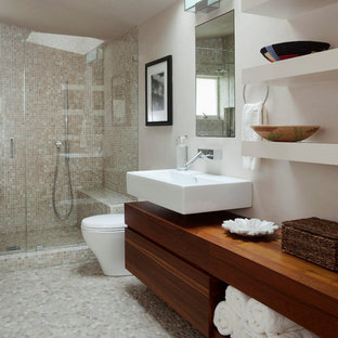Foto di una grande stanza da bagno con doccia design con lavabo sospeso, ante lisce, ante in legno bruno, doccia alcova, piastrelle beige, piastrelle a mosaico, pareti bianche, pavimento con piastrelle di ciottoli, top in legno, pavimento grigio, porta doccia a battente e top marrone