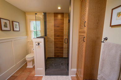 Mid-sized arts and crafts 3/4 black tile and porcelain tile porcelain tile corner shower photo in Seattle with shaker cabinets, medium tone wood cabinets, a two-piece toilet, yellow walls, a pedestal sink and tile countertops