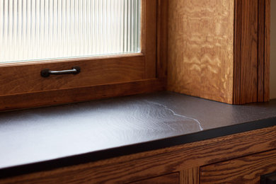 Ejemplo de cuarto de baño de estilo americano con armarios estilo shaker, puertas de armario de madera oscura y encimeras negras