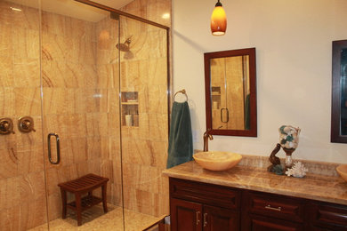 Foto på ett funkis en-suite badrum, med ett fristående handfat, luckor med upphöjd panel, skåp i mellenmörkt trä, granitbänkskiva, flerfärgad kakel, en dusch i en alkov och beige väggar