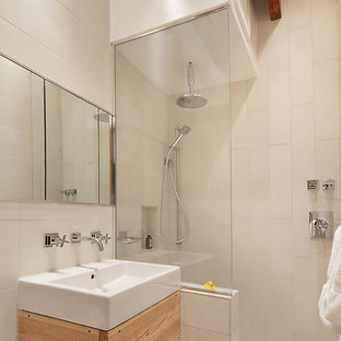 Mid-sized urban master beige tile and porcelain tile ceramic tile bathroom photo in New York with a vessel sink, flat-panel cabinets, light wood cabinets, a one-piece toilet and white walls