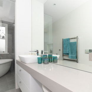Inspiration for a mid-sized modern 3/4 multicolored tile and porcelain tile porcelain tile and gray floor bathroom remodel in Sydney with flat-panel cabinets, white cabinets, a one-piece toilet, multicolored walls, a vessel sink, quartz countertops and gray countertops