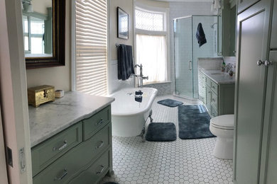 Example of a mid-sized classic master white tile and subway tile porcelain tile and white floor freestanding bathtub design in Minneapolis with recessed-panel cabinets, green cabinets, a two-piece toilet, white walls, an undermount sink, marble countertops, a hinged shower door and white countertops
