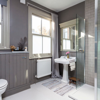 Example of a danish gray tile and subway tile corner shower design in London with a pedestal sink and gray walls