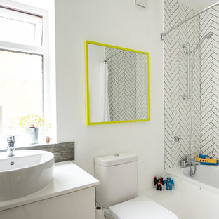 Small bohemian family bathroom in London with white cabinets, a shower/bath combination, white tiles, ceramic tiles, white walls, a built-in bath, a vessel sink, a two-piece toilet and white worktops.