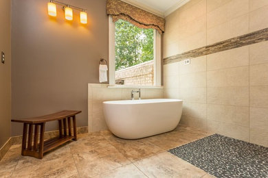 ローリーにある広いコンテンポラリースタイルのおしゃれなマスターバスルーム (置き型浴槽、バリアフリー、ベージュのタイル、グレーの壁、トラバーチンの床、ベージュの床、オープンシャワー) の写真