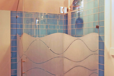 Réalisation d'une salle de bain design avec une douche d'angle et une cabine de douche à porte battante.