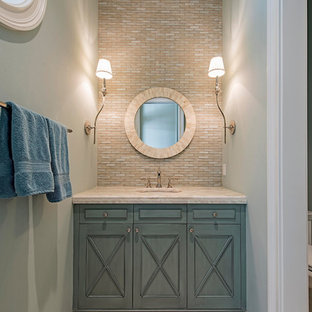 Immagine di una piccola stanza da bagno chic con consolle stile comò, WC monopezzo, piastrelle multicolore, piastrelle in pietra, lavabo sottopiano, ante turchesi, pareti blu, pavimento in marmo e top in marmo