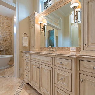 Inspiration för ett mycket stort medelhavsstil en-suite badrum, med luckor med profilerade fronter, beige skåp, ett fristående badkar, våtrum, en toalettstol med hel cisternkåpa, flerfärgad kakel, stenkakel, beige väggar, marmorgolv, ett undermonterad handfat och marmorbänkskiva