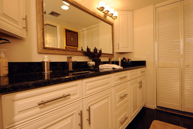 Inspiration for a mid-sized contemporary master black floor bathroom remodel in Tampa with raised-panel cabinets, white cabinets, granite countertops, white walls and an undermount sink