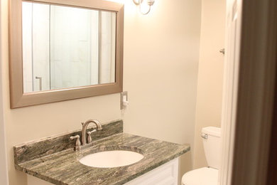 Example of a mid-sized 3/4 porcelain tile and white floor bathroom design in DC Metro with raised-panel cabinets, white cabinets, a two-piece toilet, white walls, an undermount sink, quartz countertops and gray countertops