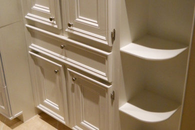 Imagen de cuarto de baño minimalista con armarios con paneles empotrados, puertas de armario blancas, paredes beige y suelo de baldosas de cerámica