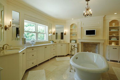 На фото: главная ванная комната в классическом стиле с фасадами с выступающей филенкой, белыми фасадами, отдельно стоящей ванной, белыми стенами, мраморным полом, врезной раковиной и столешницей из искусственного кварца