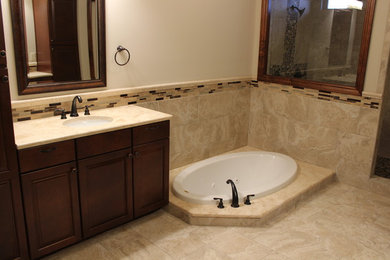 Large elegant master beige tile and porcelain tile porcelain tile bathroom photo in Wichita with recessed-panel cabinets, dark wood cabinets, beige walls, an undermount sink and granite countertops
