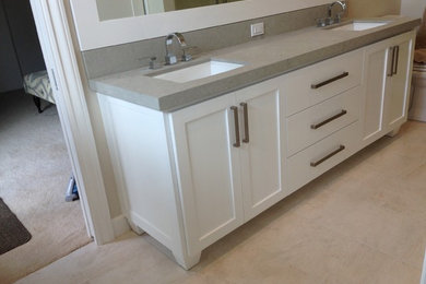 Modelo de cuarto de baño clásico con armarios estilo shaker, puertas de armario blancas, paredes beige, suelo beige y encimeras grises