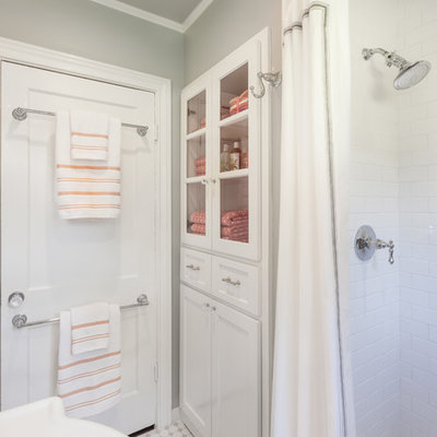 Inspiration for a small timeless 3/4 white tile and subway tile mosaic tile floor and white floor bathroom remodel in Houston with glass-front cabinets, white cabinets, marble countertops, a one-piece toilet and gray walls