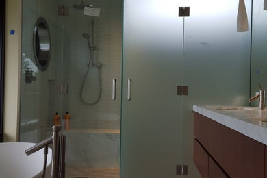 Cette image montre une salle de bain minimaliste avec un espace douche bain et une cabine de douche à porte battante.