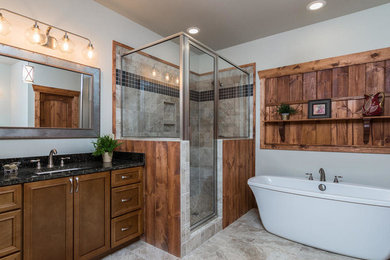 Example of a mountain style master bathroom design in Charlotte with medium tone wood cabinets, granite countertops, a hinged shower door and black countertops
