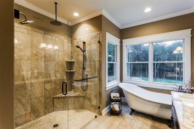 Inspiration for a large transitional master brown tile and stone tile travertine floor and brown floor bathroom remodel in Other with recessed-panel cabinets, dark wood cabinets, brown walls, an undermount sink, granite countertops and a hinged shower door