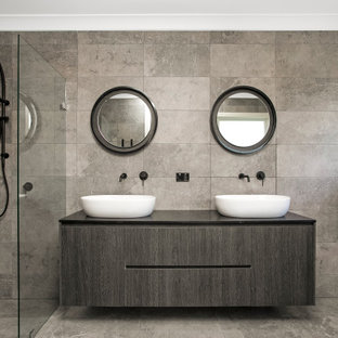 Photo of a contemporary bathroom in Sydney with flat-panel cabinets, grey cabinets, gray tile, a vessel sink, grey floor, black benchtops and a double vanity.