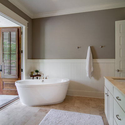 Freestanding bathtub - traditional master beige tile limestone floor freestanding bathtub idea in Nashville with shaker cabinets, beige cabinets and an undermount sink