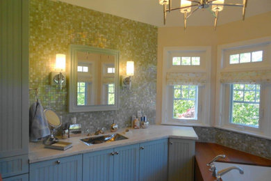 Example of a mid-century modern master green tile and ceramic tile single-sink corner bathtub design in Portland Maine with green cabinets, green walls, a drop-in sink and a freestanding vanity