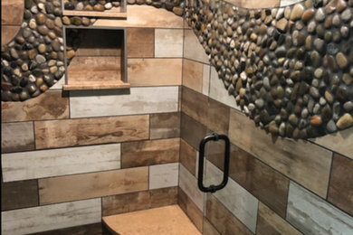 Mid-sized elegant master beige tile, brown tile, gray tile and porcelain tile pebble tile floor and multicolored floor corner shower photo in Other with a two-piece toilet, multicolored walls and a hinged shower door