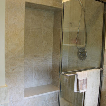 Custom seated alcove in shower area is an added plus in a small bathroom