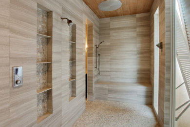 Walk-in shower - large modern stone tile limestone floor walk-in shower idea in New Orleans with beige walls