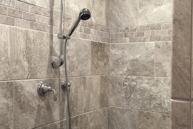 グランドラピッズにある広いトラディショナルスタイルのおしゃれなマスターバスルーム (アルコーブ型シャワー、グレーのタイル、セラミックタイル、グレーの壁) の写真