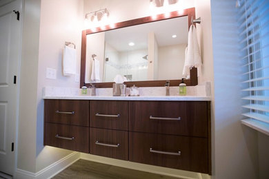 Example of a mid-sized transitional 3/4 gray tile and matchstick tile medium tone wood floor and brown floor corner shower design in Other with flat-panel cabinets, dark wood cabinets, beige walls, an undermount sink, marble countertops and a hinged shower door