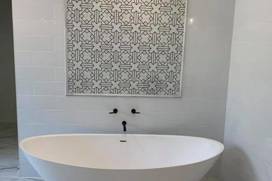 Modelo de cuarto de baño principal contemporáneo con bañera exenta, baldosas y/o azulejos grises, baldosas y/o azulejos de cemento, suelo de mármol y suelo blanco