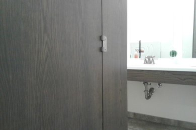 Imagen de cuarto de baño contemporáneo de tamaño medio con armarios con paneles con relieve, puertas de armario de madera en tonos medios, encimera de acrílico y encimeras blancas