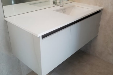 Diseño de cuarto de baño minimalista pequeño con armarios con paneles lisos, puertas de armario blancas, lavabo integrado y encimeras blancas