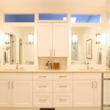 Custom white Cabinetry in a modern glass and porcelain  bathroom.