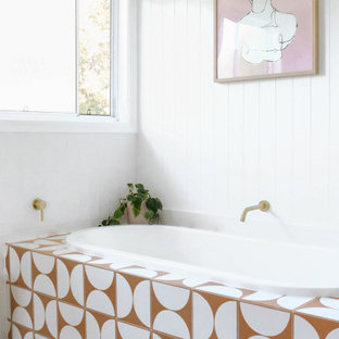 Design ideas for a beach style bathroom in Gold Coast - Tweed with white cabinets and wood benchtops.