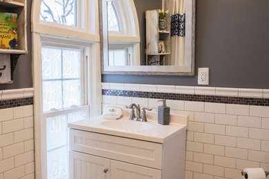 Small classic family bathroom in Wichita with freestanding cabinets, white cabinets, an alcove bath, an alcove shower, white tiles, ceramic tiles, grey walls, ceramic flooring and an integrated sink.