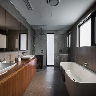 This is an example of a mid-sized contemporary bathroom in Canberra - Queanbeyan with flat-panel cabinets, medium wood cabinets, black tile, porcelain tile, black walls, porcelain floors, a vessel sink, wood benchtops, black floor, an open shower, a freestanding tub, a double shower and brown benchtops.