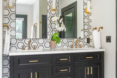 Mid-sized transitional 3/4 black and white tile and marble tile marble floor and white floor alcove shower photo in Dallas with black cabinets, a two-piece toilet, white walls, an undermount sink, quartz countertops, a hinged shower door, white countertops and recessed-panel cabinets