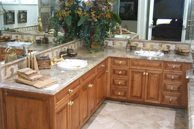 Example of a trendy master marble floor corner shower design in Orange County with raised-panel cabinets, medium tone wood cabinets, an undermount tub, a one-piece toilet, white walls, a drop-in sink and marble countertops