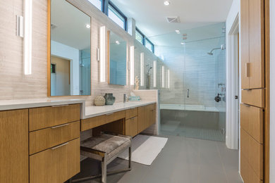 Exemple d'une salle de bain tendance en bois brun avec un placard à porte plane, une baignoire posée, un espace douche bain, un carrelage gris, un mur blanc, un lavabo encastré, un sol gris et un plan de toilette blanc.