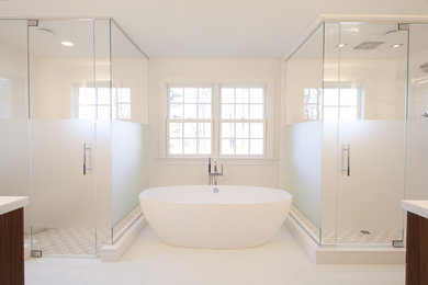 Photo of a large contemporary ensuite bathroom in New York with flat-panel cabinets, dark wood cabinets, a freestanding bath, a corner shower, white tiles, marble tiles, white walls, porcelain flooring, a built-in sink, solid surface worktops, white floors, a hinged door and white worktops.