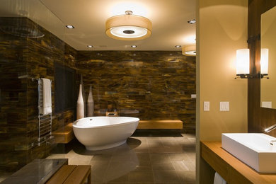 This is an example of a contemporary bathroom in Austin with a freestanding bath, a vessel sink and feature lighting.