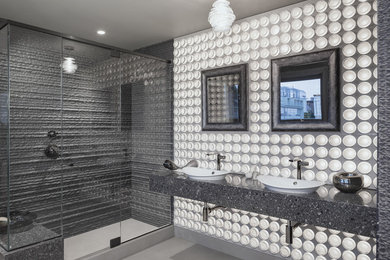 Modelo de cuarto de baño contemporáneo grande con sanitario de una pieza, baldosas y/o azulejos grises, paredes grises, lavabo sobreencimera, encimera de cuarzo compacto, suelo gris y ducha con puerta con bisagras